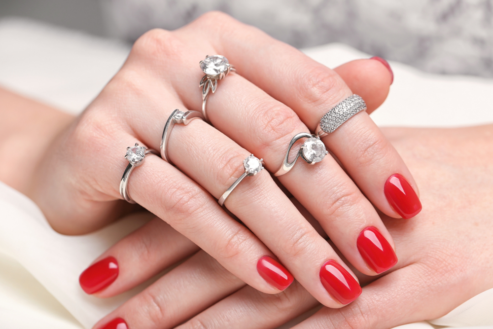 ダイヤモンドの婚約指輪をたくさん着ける女性の手