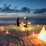 海外旅行先のビーチでロマンチックなディナーを過ごすカップル