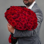108本の薔薇の花束を持ってプロポーズする男性