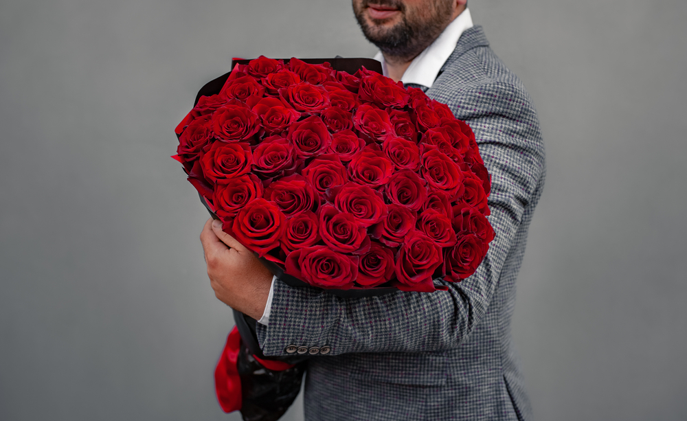 108本の薔薇の花束を持ってプロポーズする男性