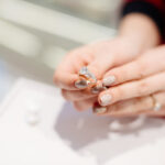 宝石店で婚約指輪を試着している女性