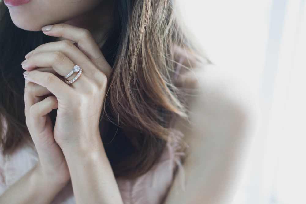 婚約指輪と結婚指輪のセットリングを重ね付けする女性