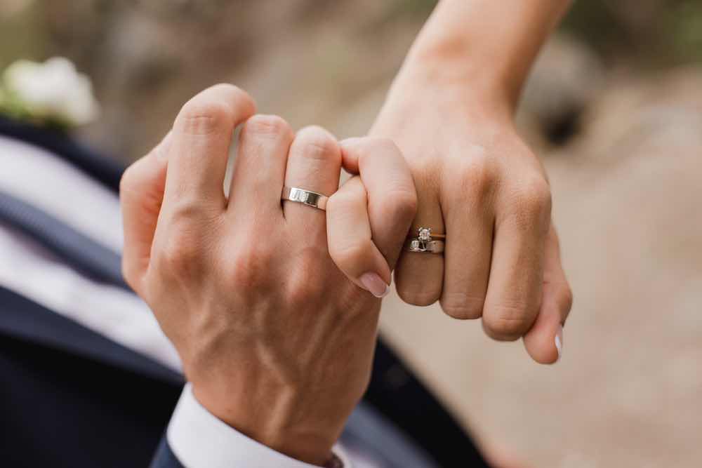 婚約指輪と結婚指輪をつけたカップル