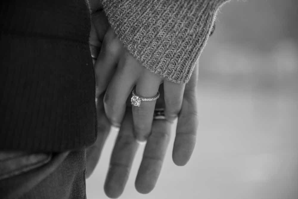 婚約指輪を身につけて手をつなぐカップル