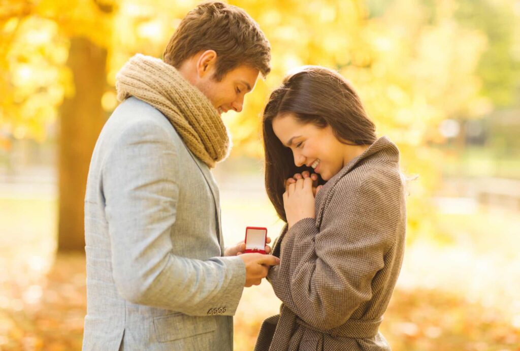 若いカップルが向き合って婚約指輪を見つめている